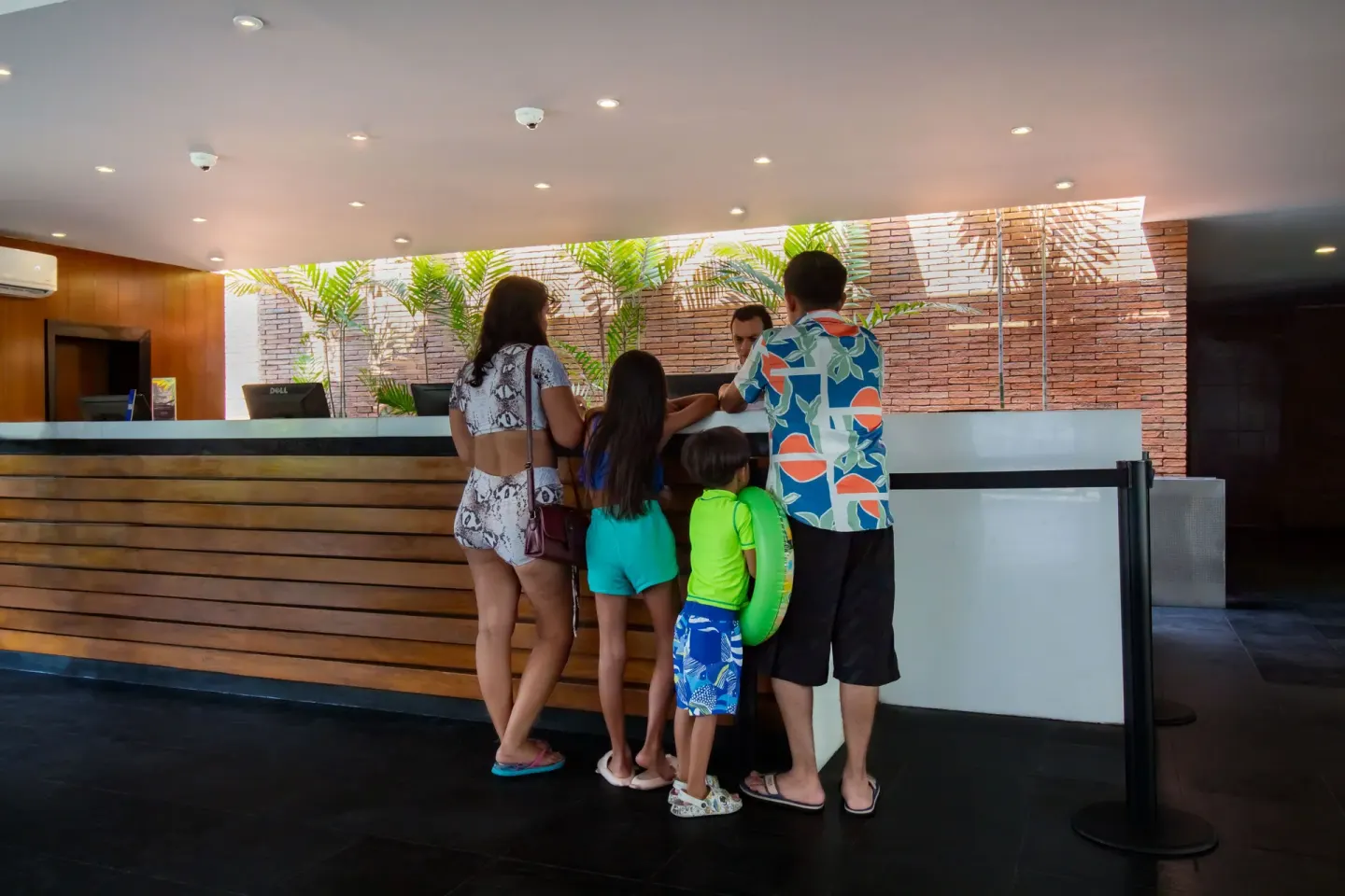 Guests check in at the front desk in the lobby of Plaza Pelicanos Club Beach Resort.