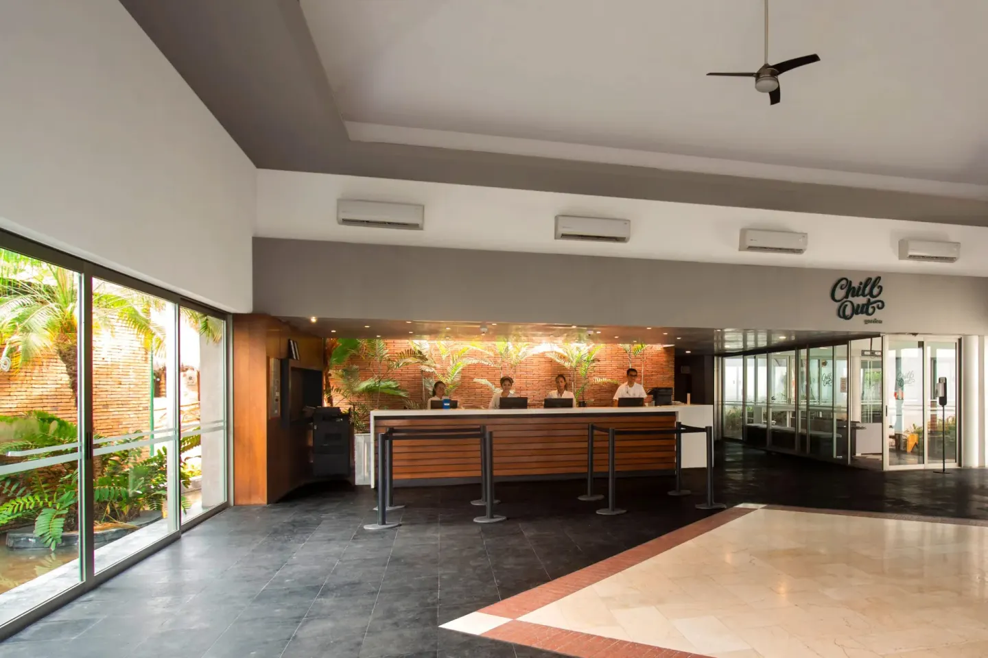 Reception desk and glass-lined lobby area at Plaza Pelicanos Club Beach Resort.