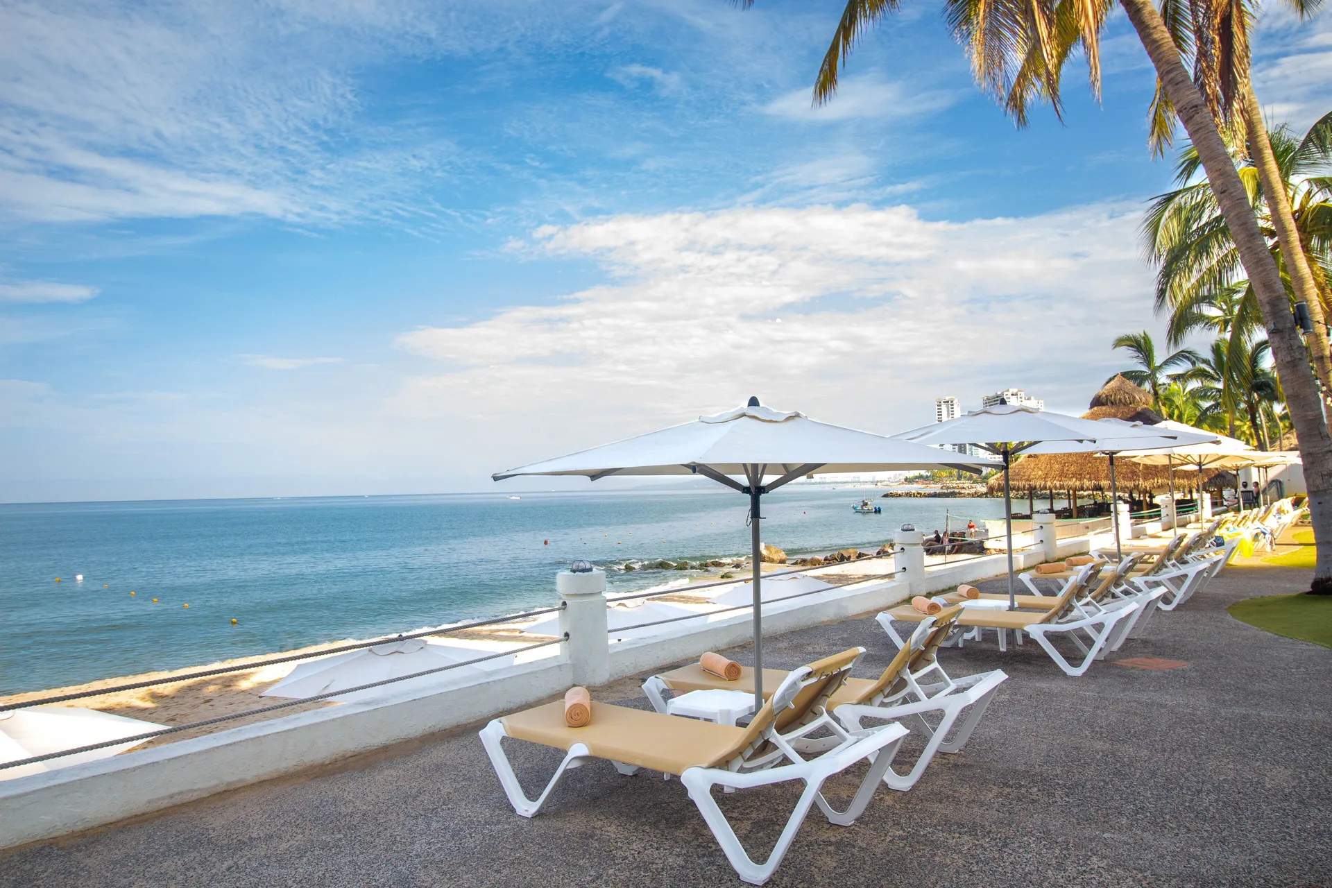 Oceanfront lounge chairs and umbrellas at Plaza Pelicanos Club Beach Resort.