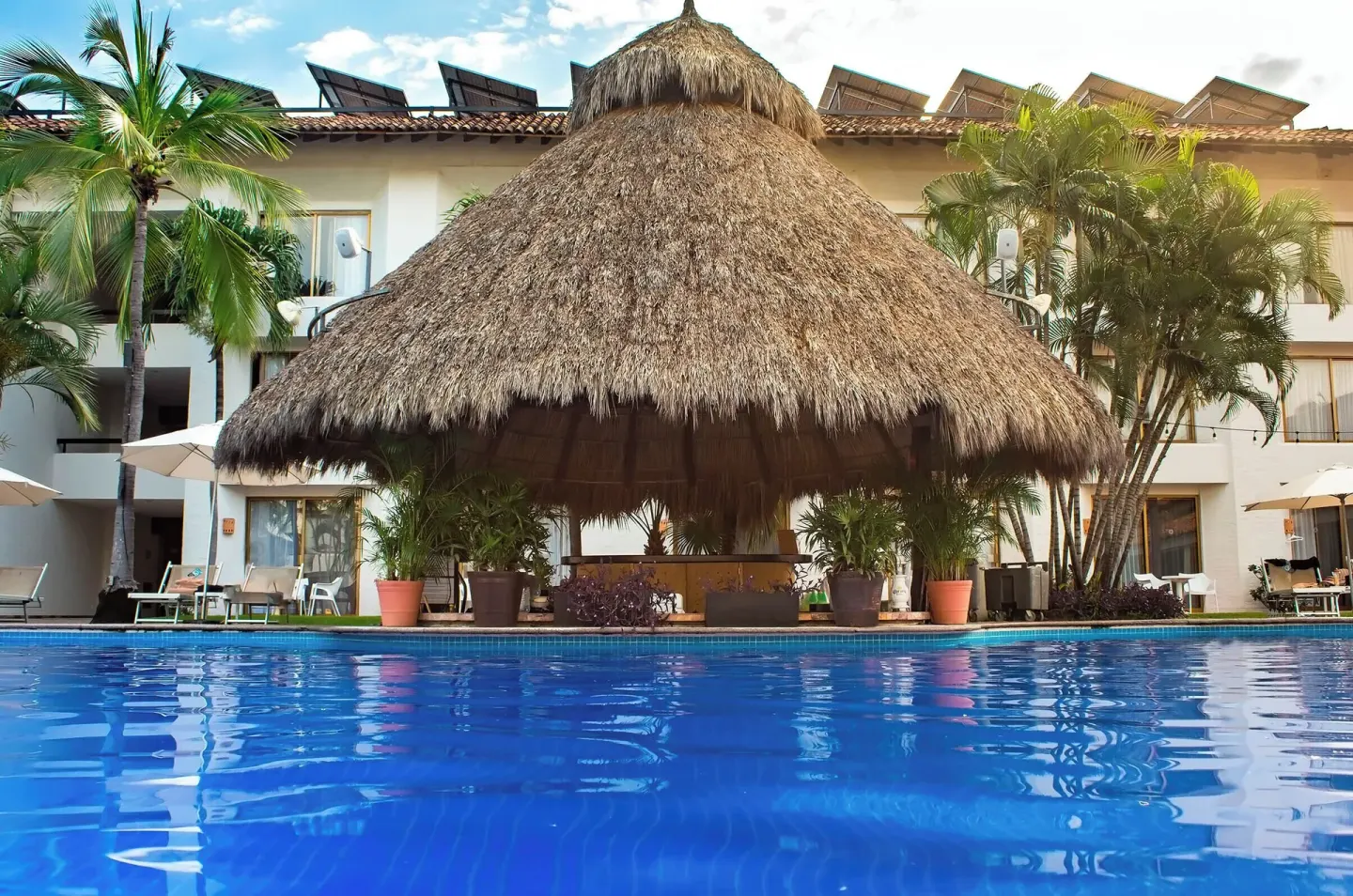 Poolside palapa and guest buildings at Plaza Pelicanos Club Beach Resort.