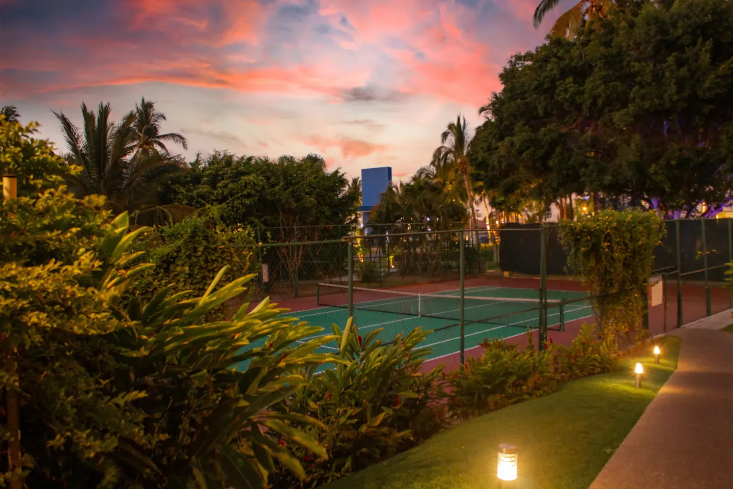 Tennis court and gardens at sunset at Plaza Pelicanos Club Beach Resort.
