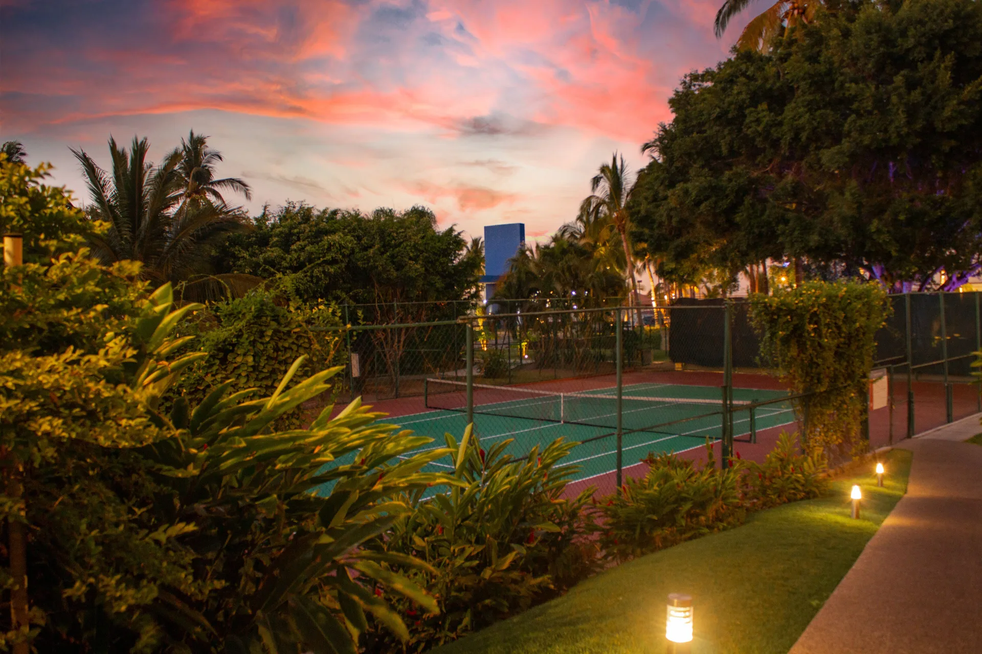 Tennis court and gardens at sunset at Plaza Pelicanos Club Beach Resort.