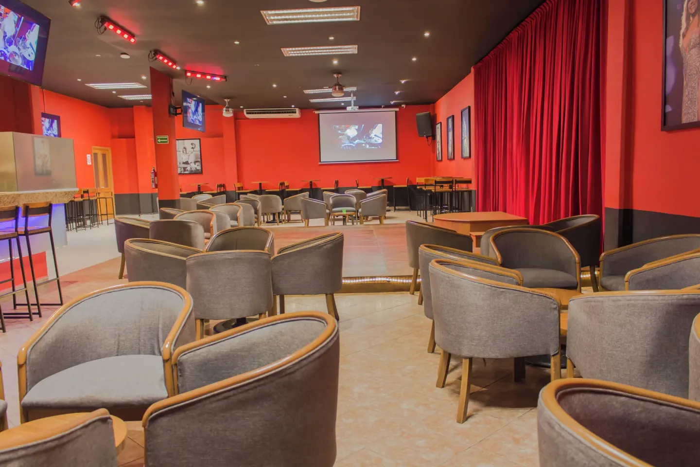 Red sports bar lounge with TVs and projector at Plaza Pelicanos Club Beach Resort.