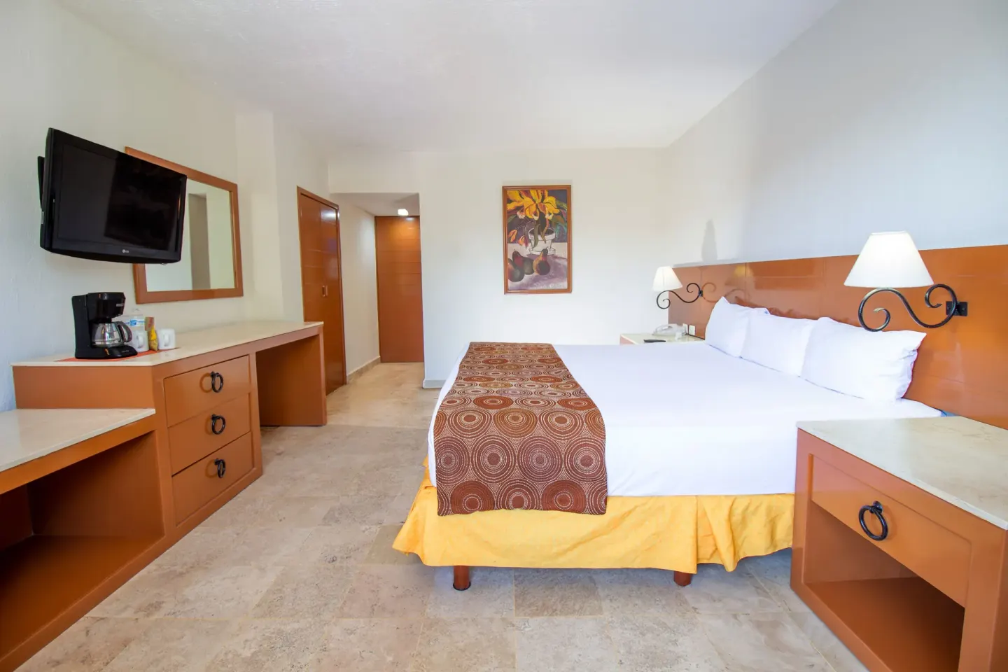 Standard room king bed with nightstands and dresser at Plaza Pelicanos Club Beach Resort.