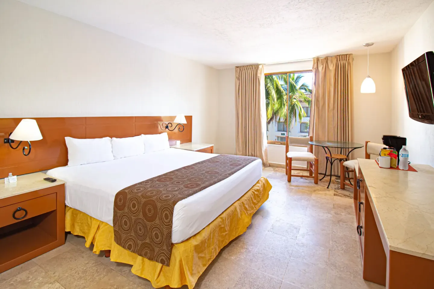 Standard room with king bed and window at Plaza Pelicanos Club Beach Resort.