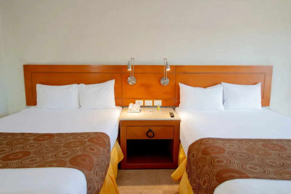 Standard Room two-bed headboard and nightstand at Plaza Pelicanos Club Beach Resort.