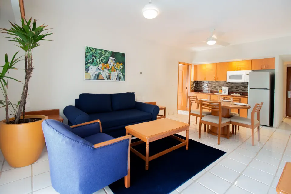 One-bedroom suite living area with sofa and kitchenette at Plaza Pelicanos Club Beach Resort.