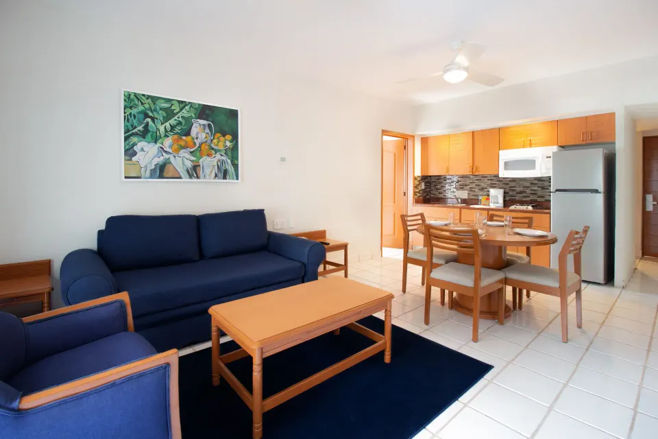 One-bedroom suite living room with dining table at Plaza Pelicanos Club Beach Resort.
