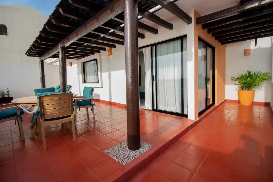 One-bedroom suite terrace with seating at Plaza Pelicanos Club Beach Resort.