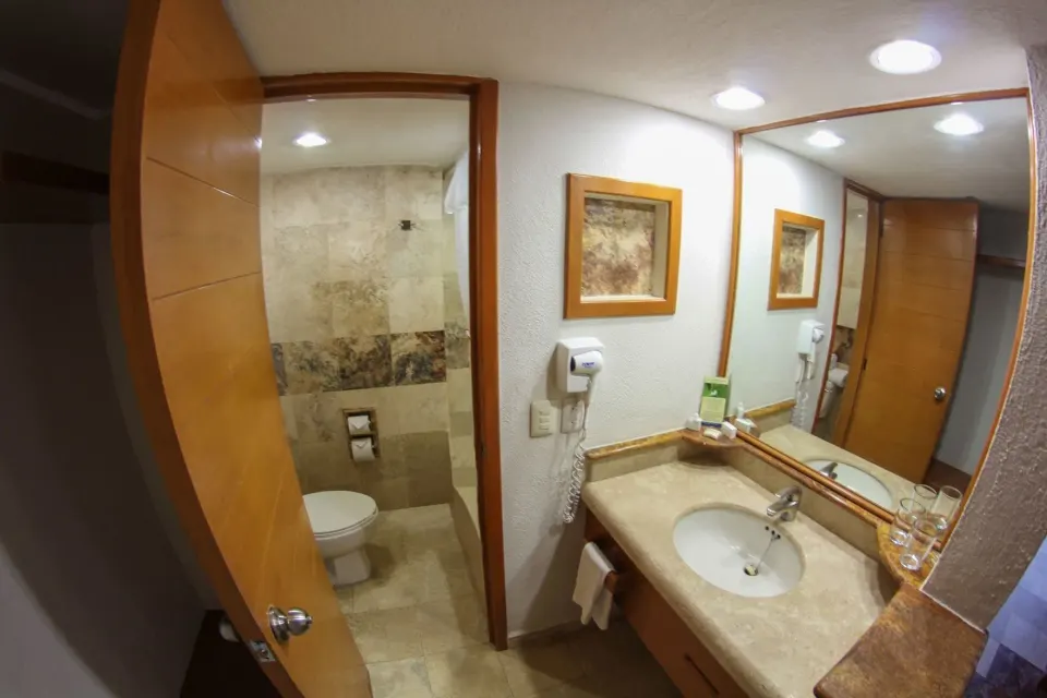 Superior room bathroom vanity and toilet area at Plaza Pelicanos Club Beach Resort.