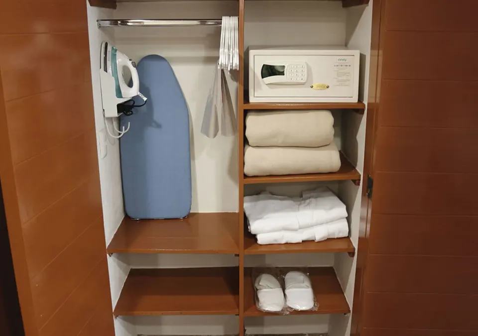 Superior Room closet at Plaza Pelicanos Club Beach Resort with safe, ironing board, robes and slippers.
