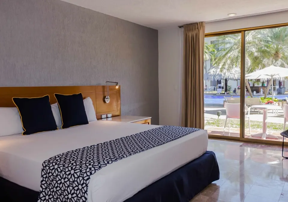 Superior room with king bed and terrace pool view at Plaza Pelicanos Club Beach Resort.