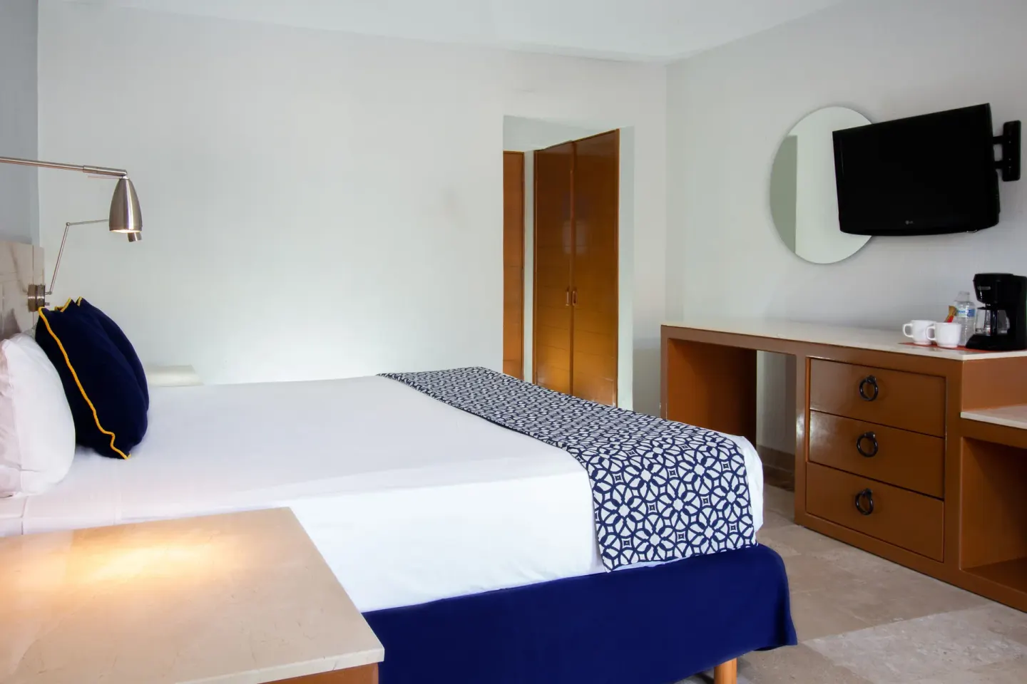 Superior Room king bed with dresser, TV, mirror and closet at Plaza Pelicanos Club Beach Resort.