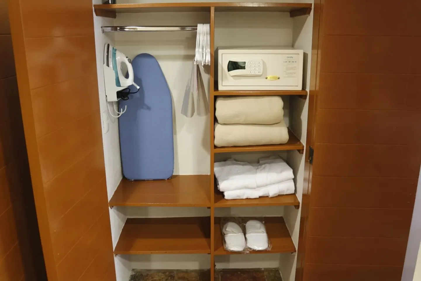 Superior Room closet at Plaza Pelicanos Club Beach Resort with open shelves, safe and ironing board.