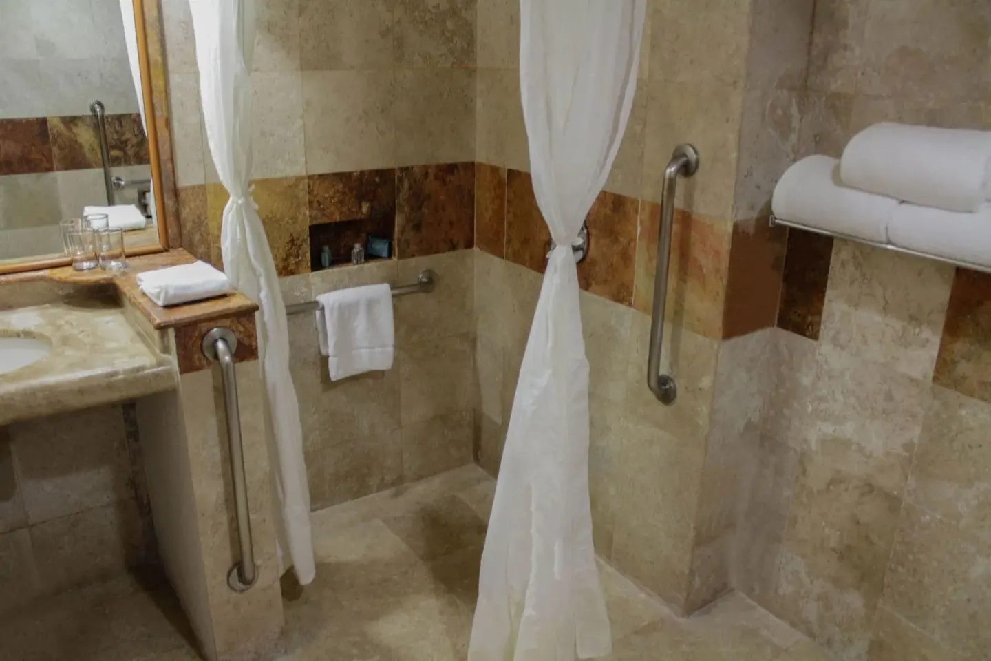 Superior Room shower area at Plaza Pelicanos Club Beach Resort with curtain, grab bars and towel shelf.