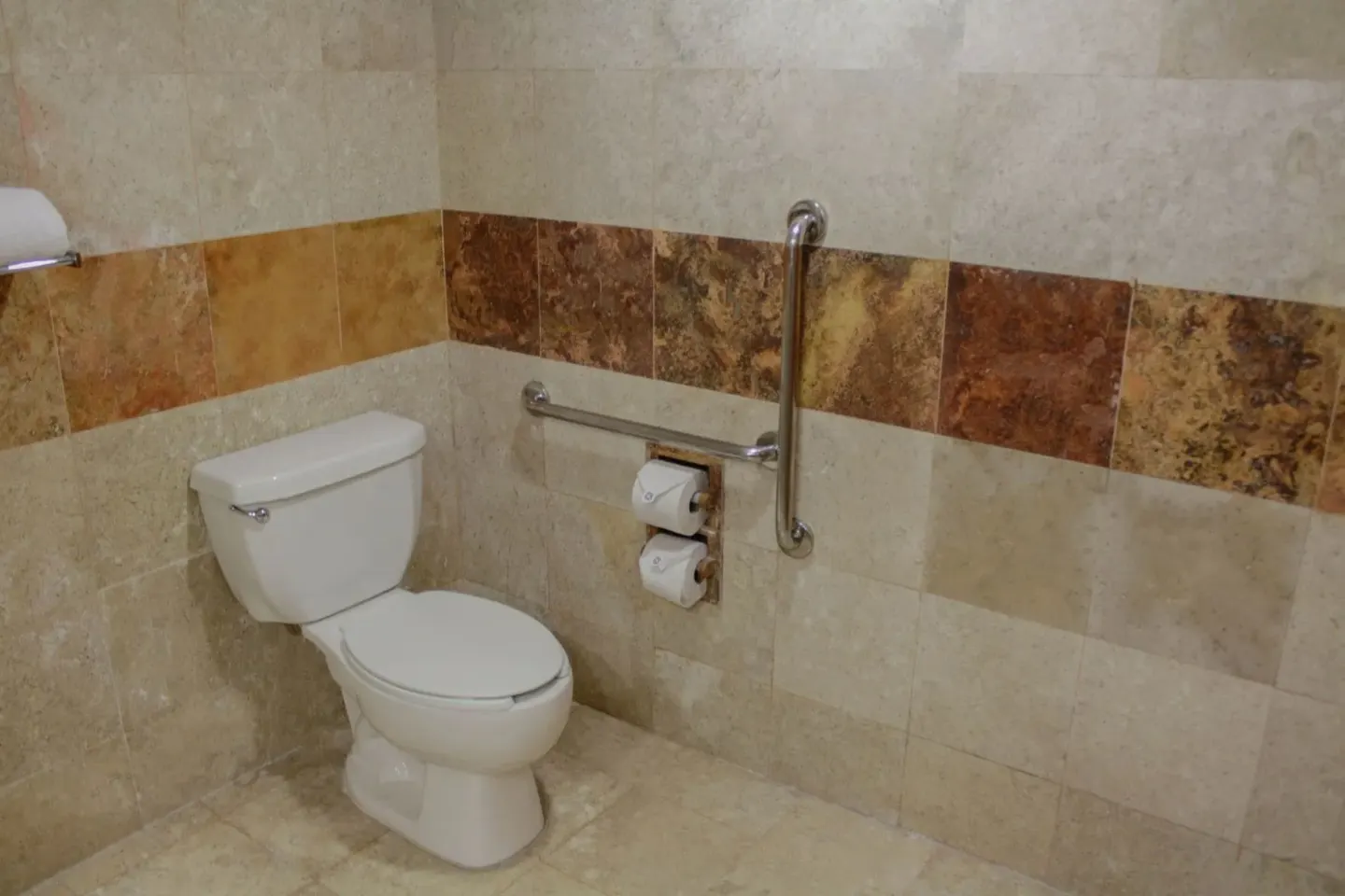 Superior Room toilet area at Plaza Pelicanos Club Beach Resort with tiled walls and grab bars.
