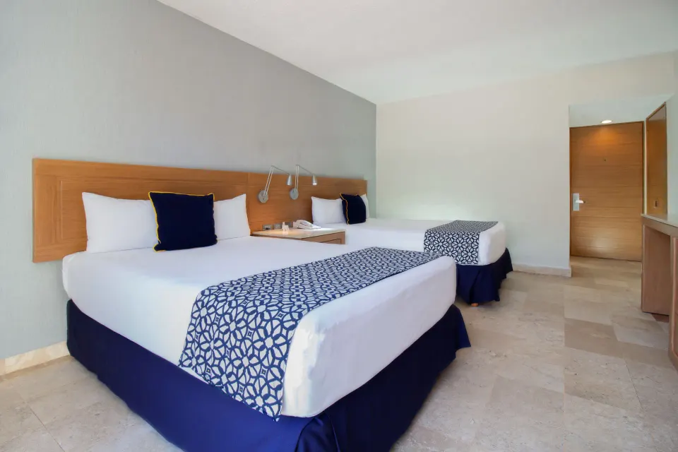 Superior Room with two beds and entry door visible at Plaza Pelicanos Club Beach Resort.