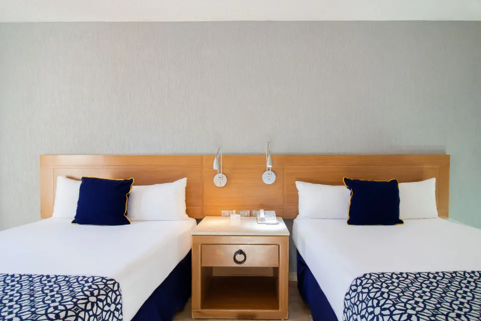 Superior Room twin-bed detail with nightstand at Plaza Pelicanos Club Beach Resort.
