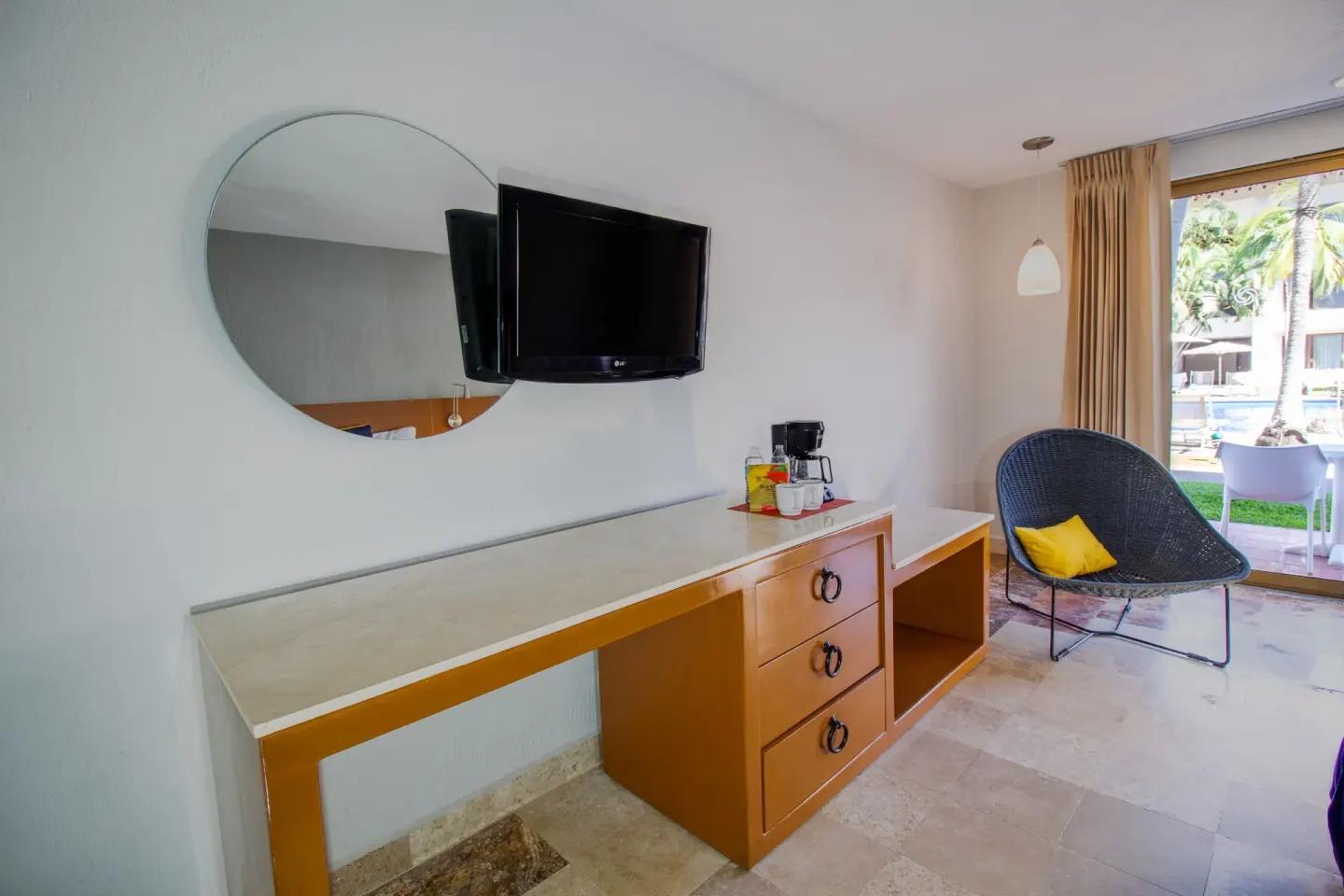 Superior room dresser, TV, mirror, and chair at Plaza Pelicanos Club Beach Resort.
