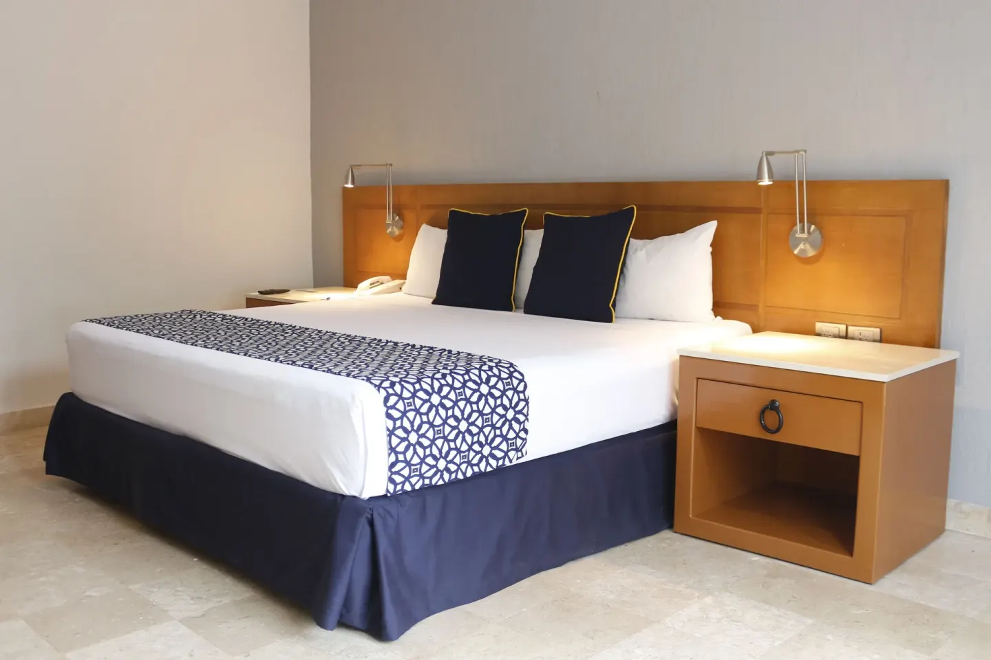 Superior king bed guest room at Plaza Pelicanos Club Beach Resort with wood headboard and nightstands.