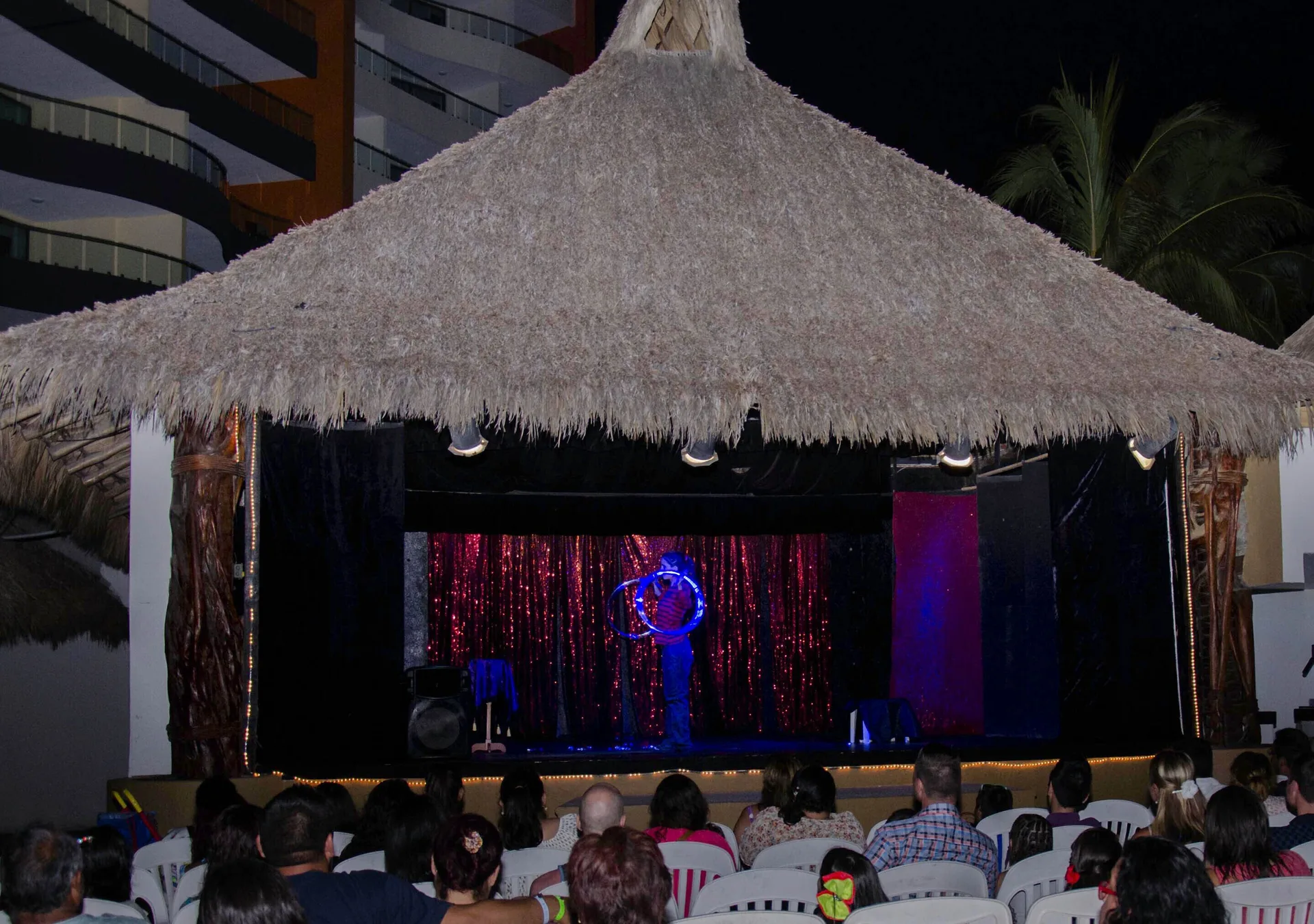 An evening stage show under a thatched palapa at Plaza Pelicanos Club Beach Resort.