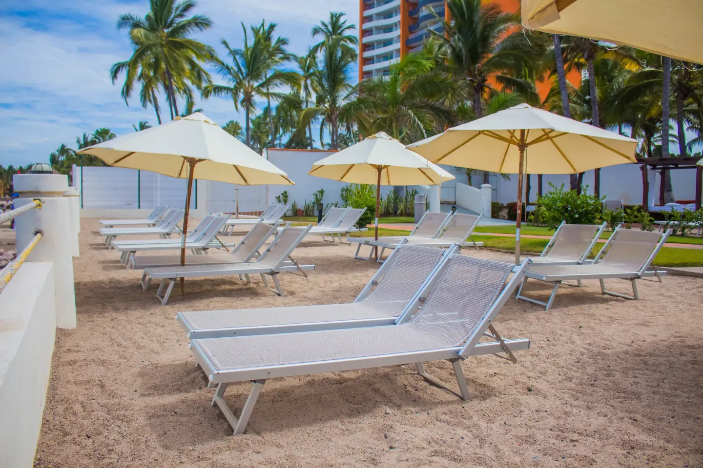 Beach loungers and umbrellas on the sand at Plaza Pelicanos Grand Beach Resort.