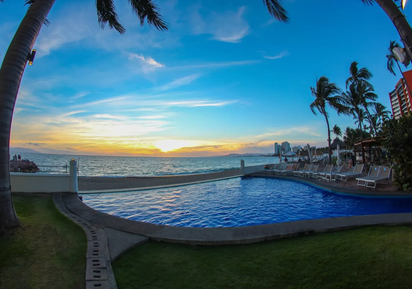 Sunset over the beachfront pool at Plaza Pelicanos Grand Beach Resort.