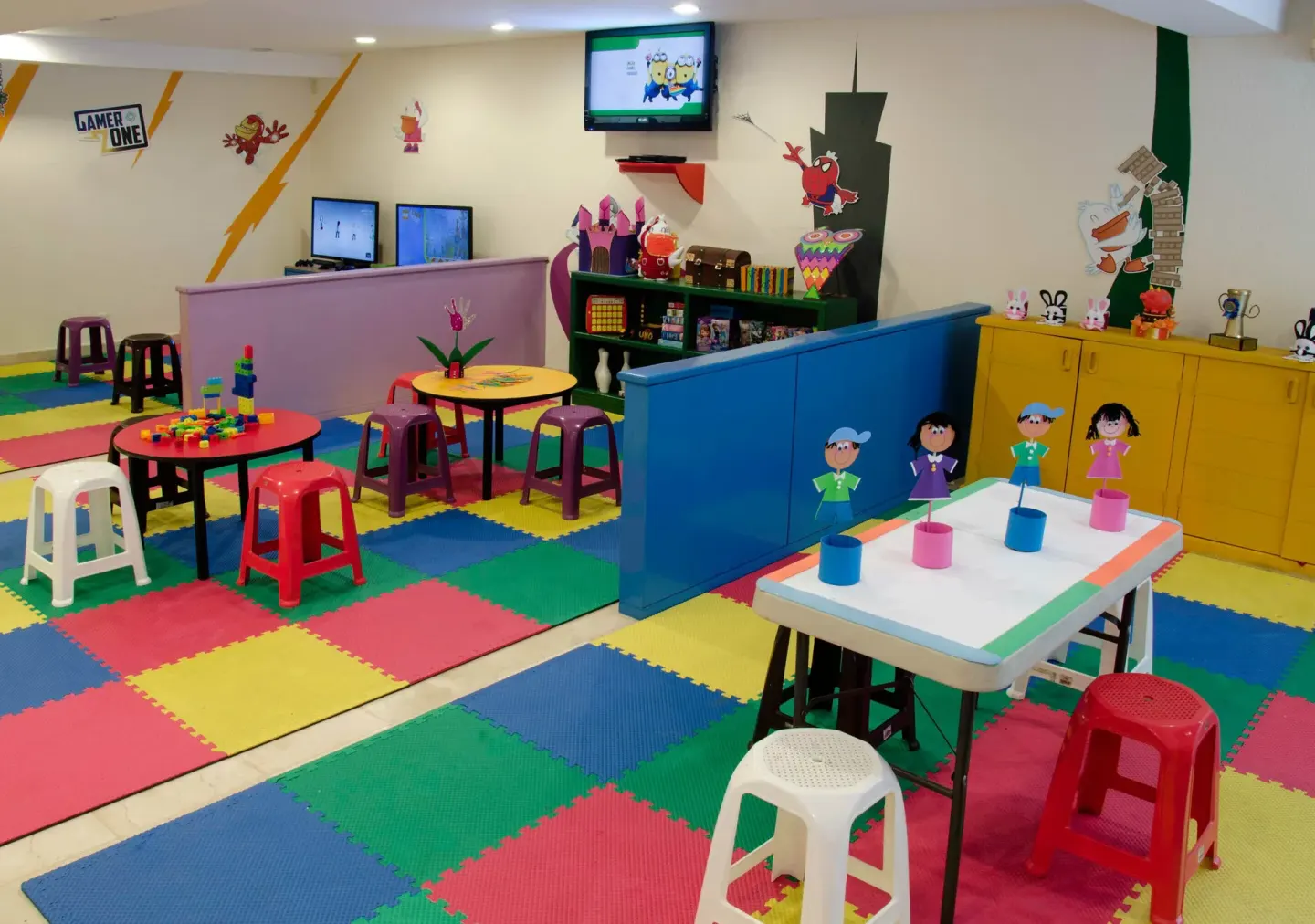 Kids activity room with small tables, stools and toys at Plaza Pelicanos Grand Beach Resort.