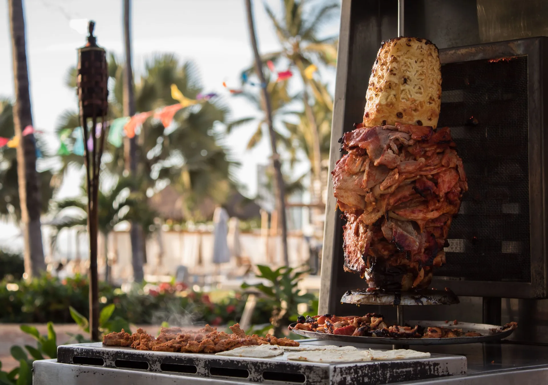 Tacos al pastor cooking outdoors at Plaza Pelicanos Grand Beach Resort.