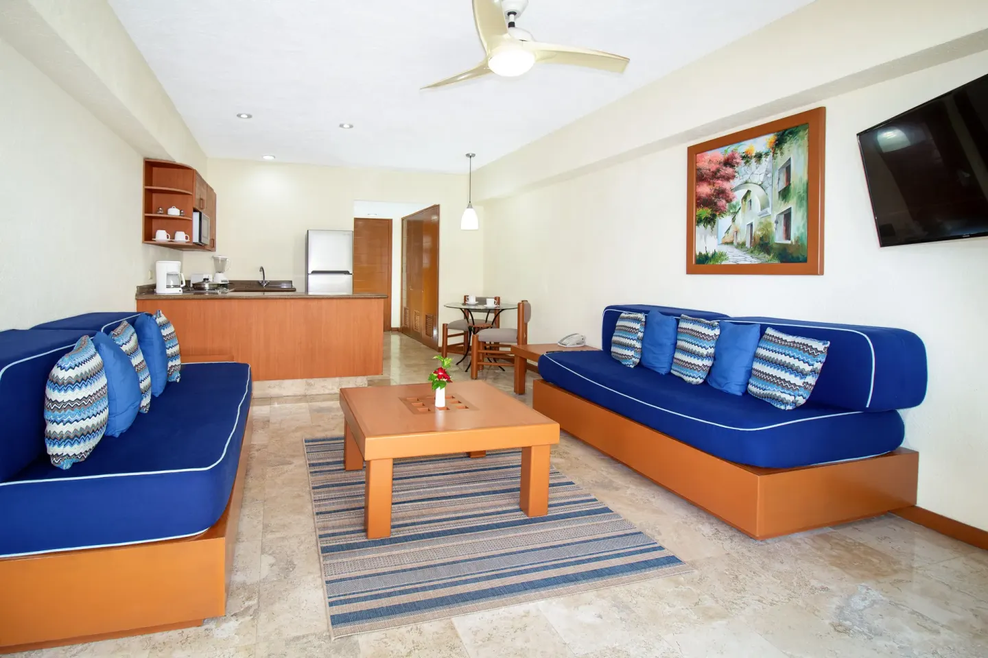 One Bedroom Suite living area with blue sofas at Plaza Pelicanos Grand Beach Resort.