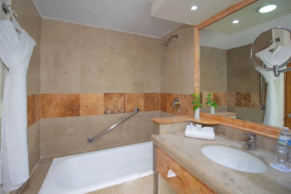Standard Room bathroom with tub and vanity at Plaza Pelicanos Grand Beach Resort.