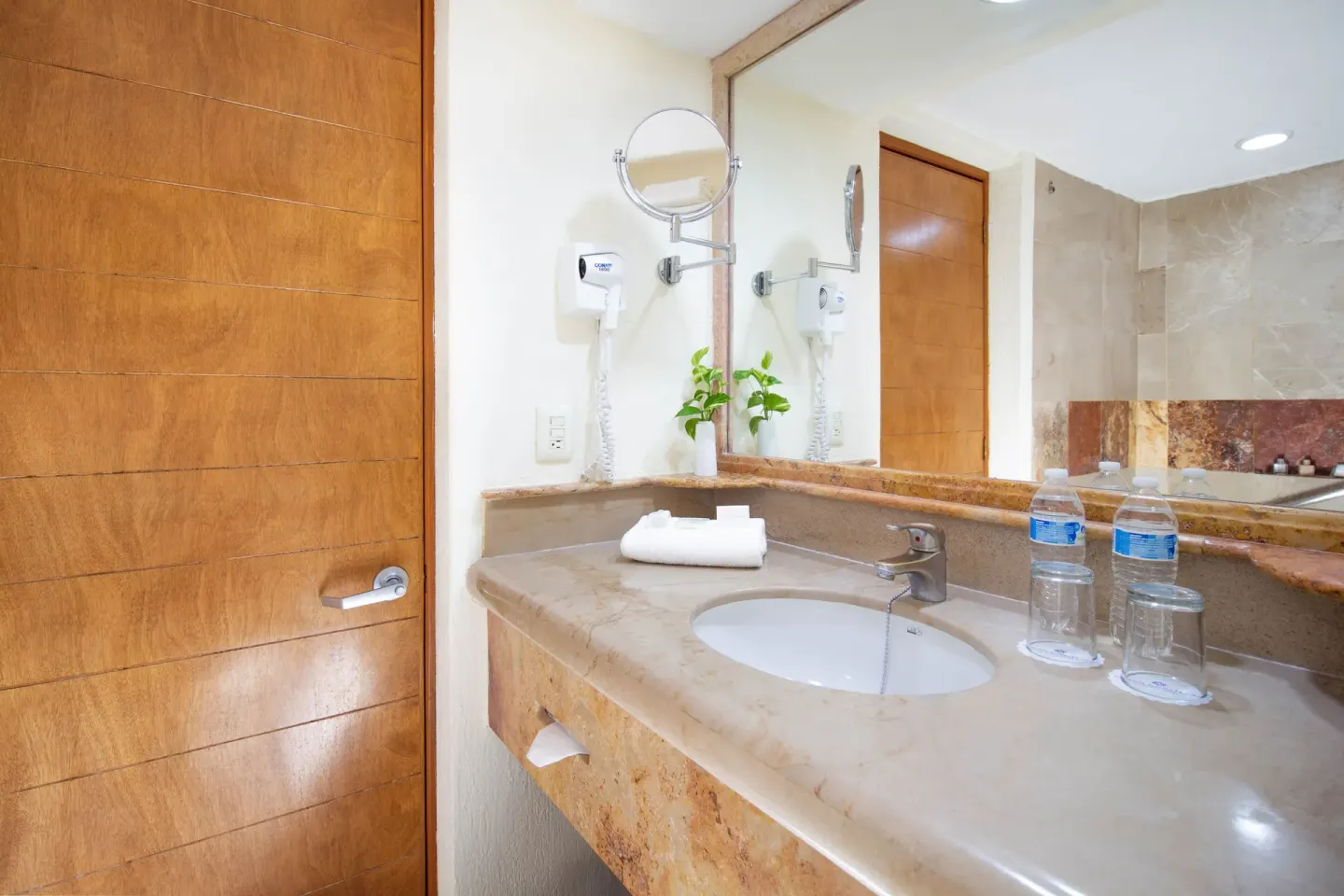 Standard Room bathroom vanity with mirror at Plaza Pelicanos Grand Beach Resort.