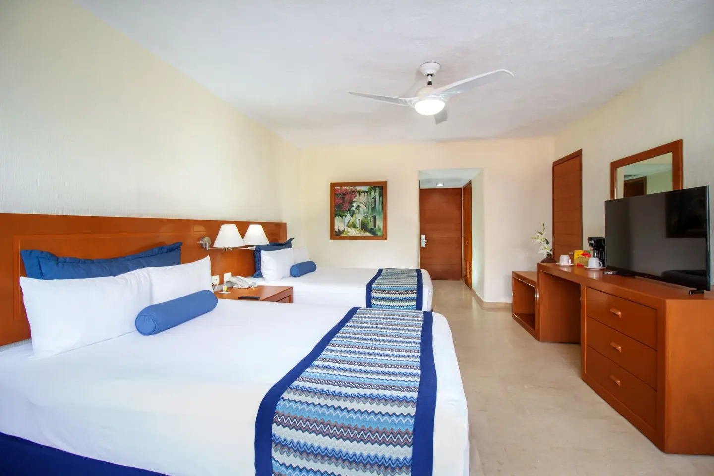 Standard Room with two beds and TV dresser at Plaza Pelicanos Grand Beach Resort.