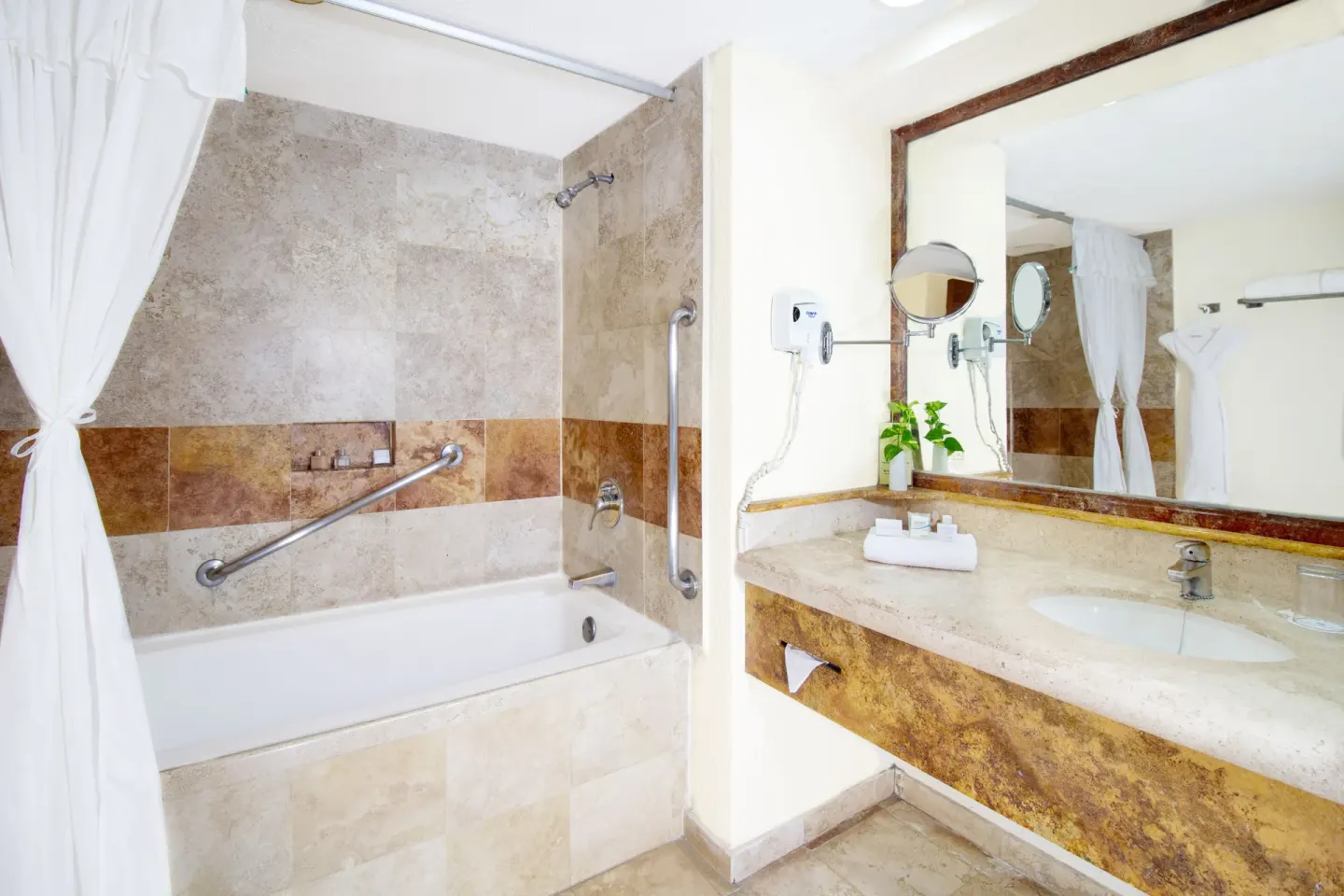 Suite bathroom with tub-shower and vanity at Plaza Pelicanos Grand Beach Resort.