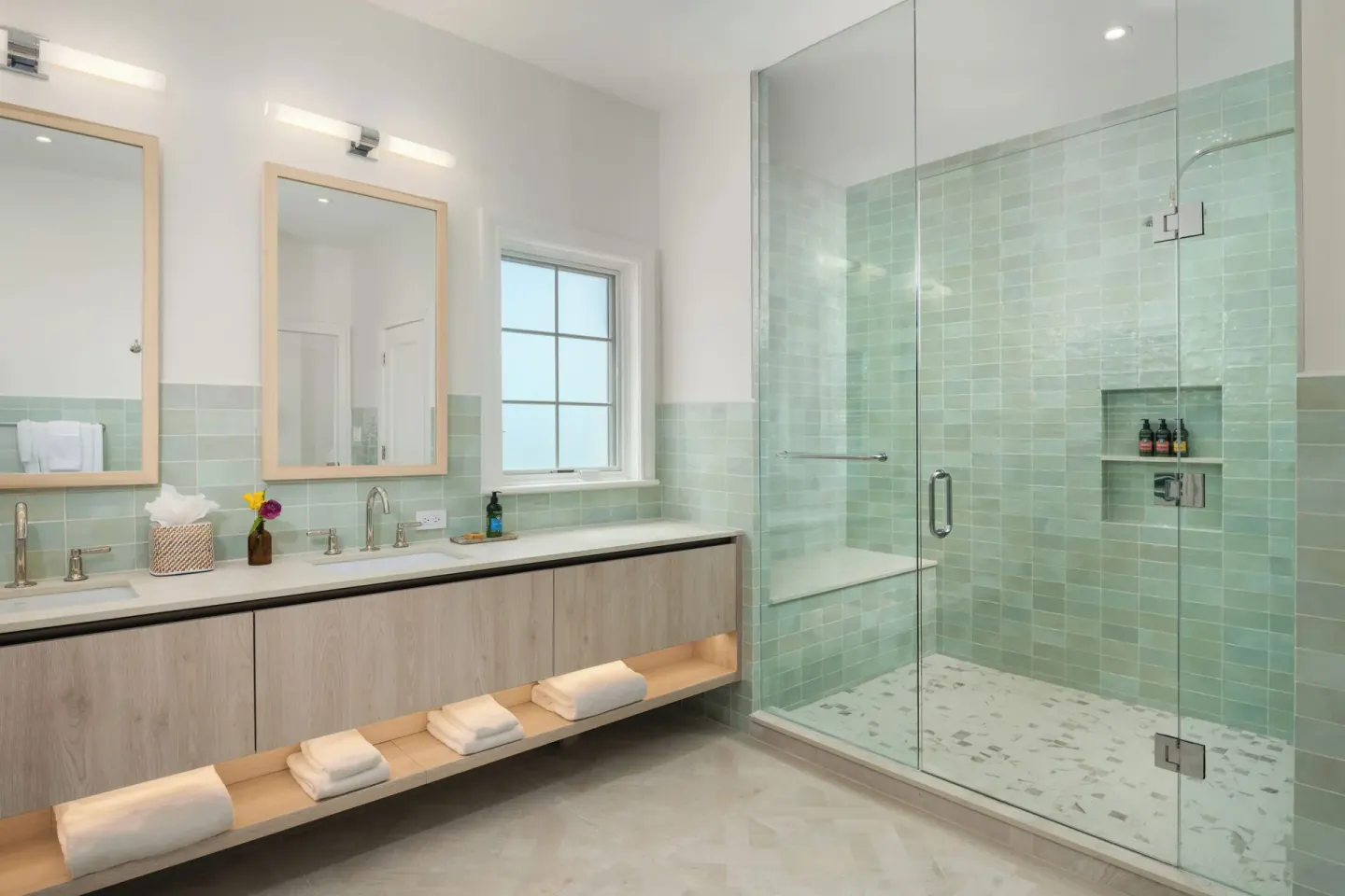 Spacious bathroom with double vanity and glass shower at Point Grace.