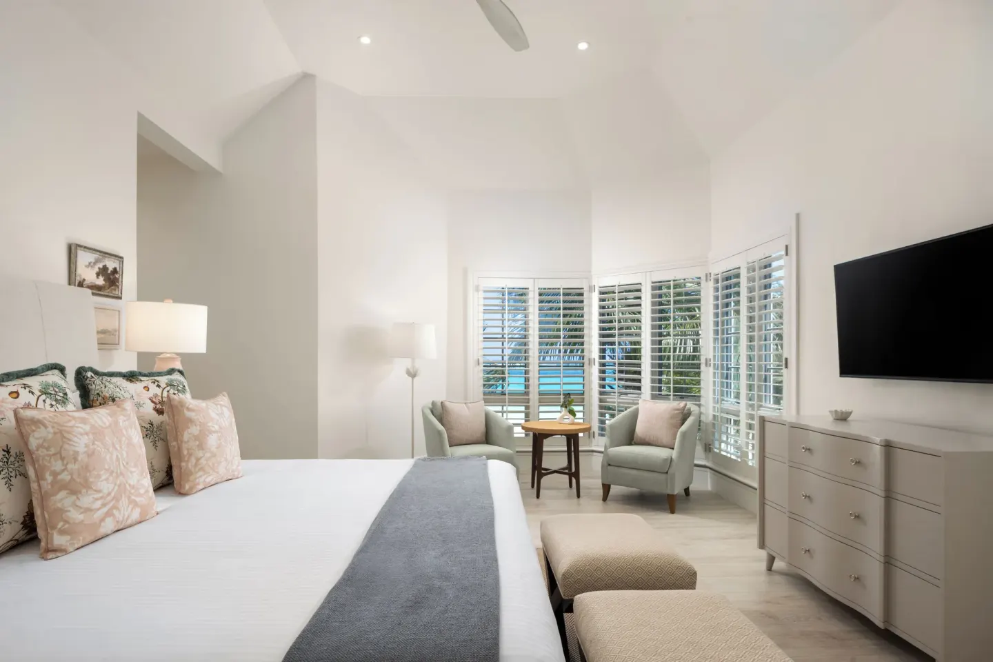 Guest room with king bed, seating area and shutters at Point Grace.