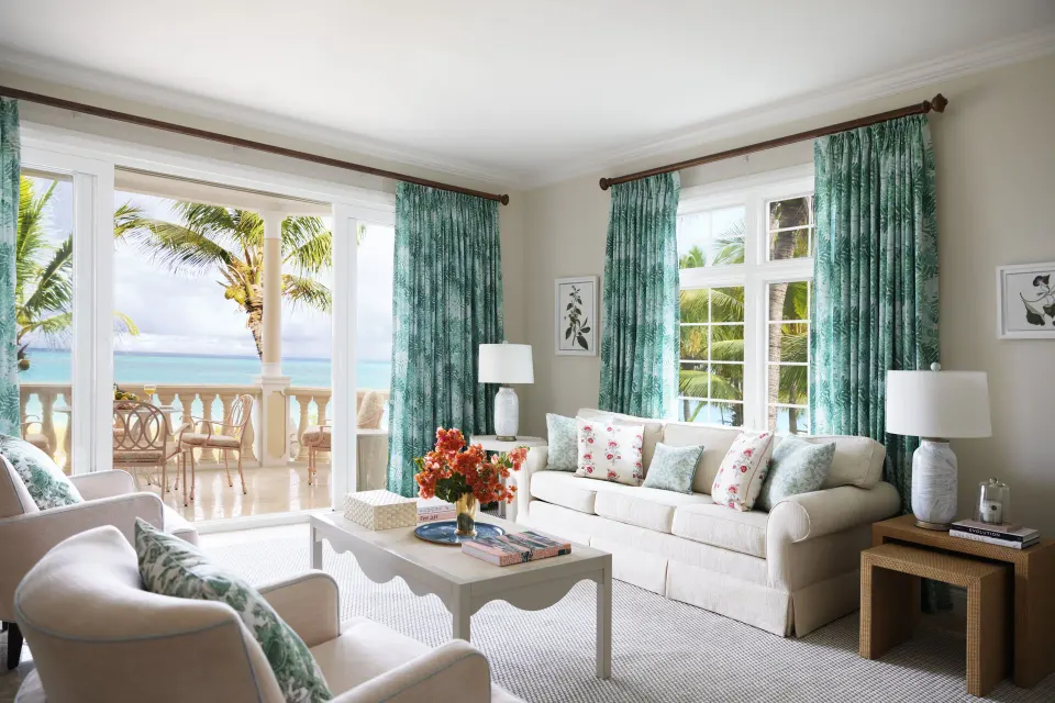 Ocean-view guest room living area opening to a balcony at Point Grace.