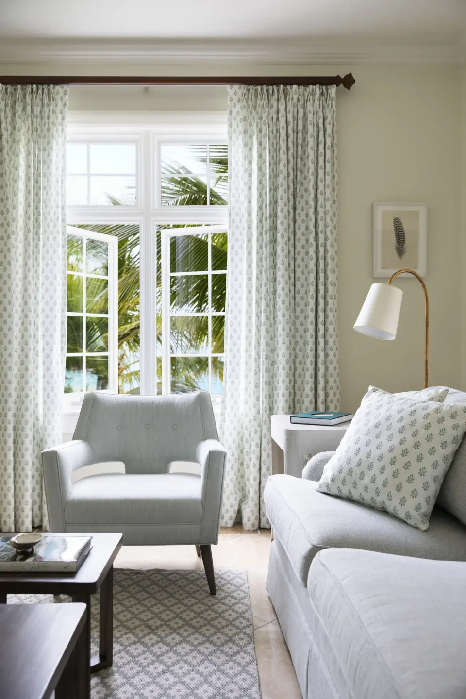 Sitting area with sofa, armchair and patterned curtains at Point Grace.