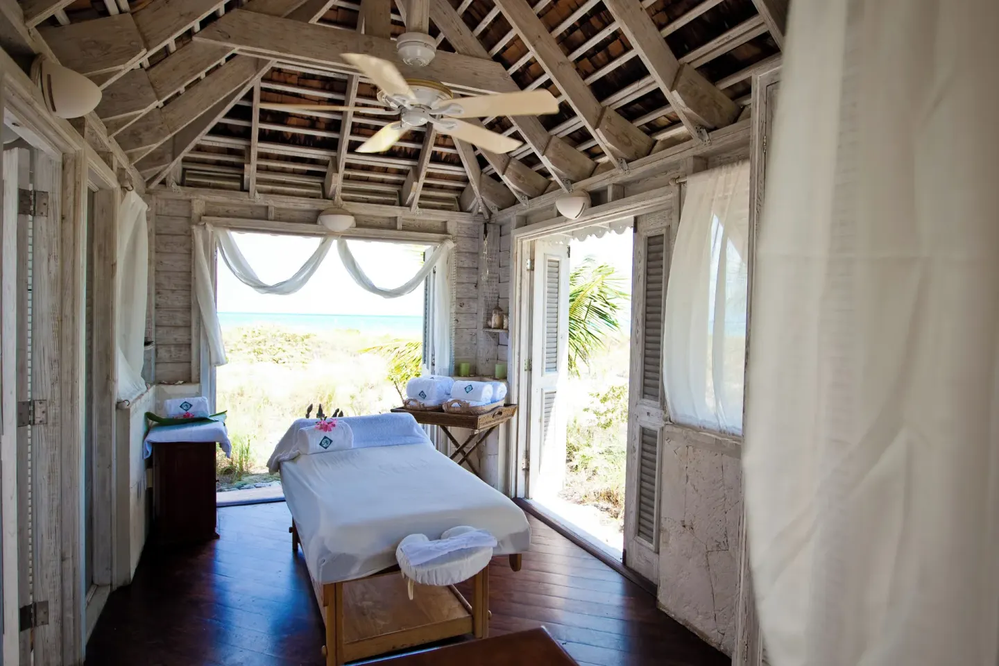 Open-air spa treatment room with massage table and ocean view at Point Grace.