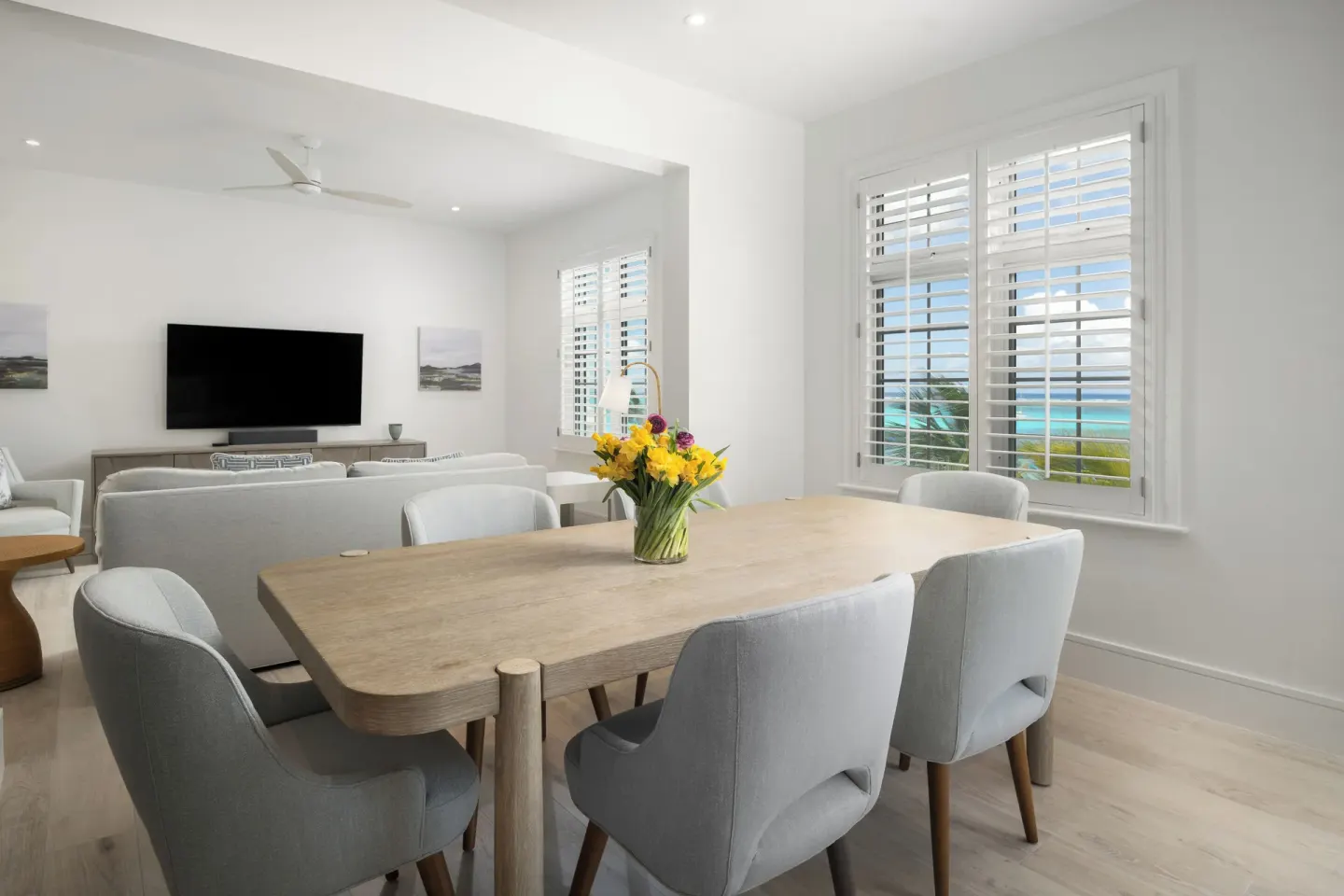 Suite dining table and living area with ocean view windows at Point Grace.
