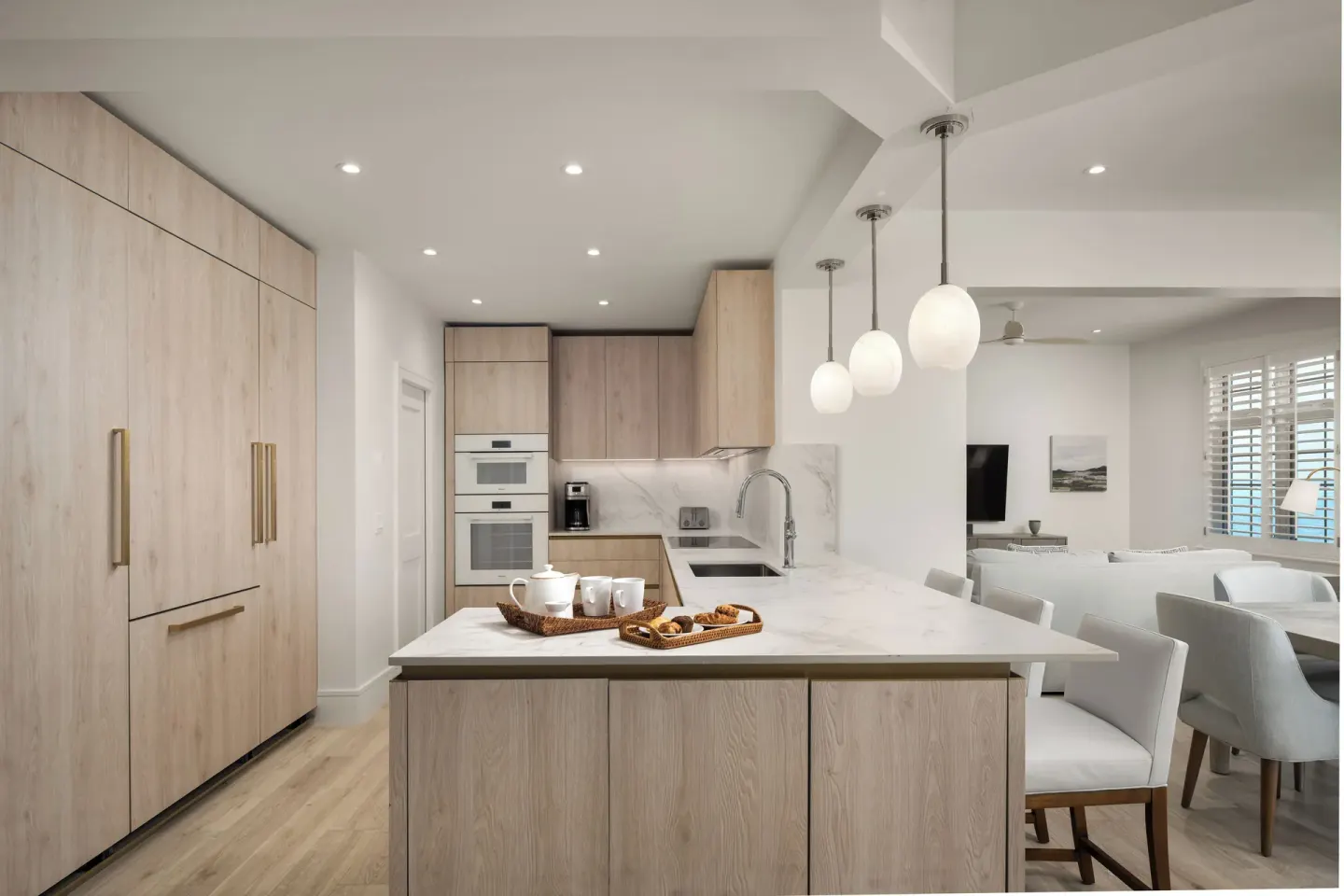 Suite kitchen with island, pendant lights and dining area at Point Grace.