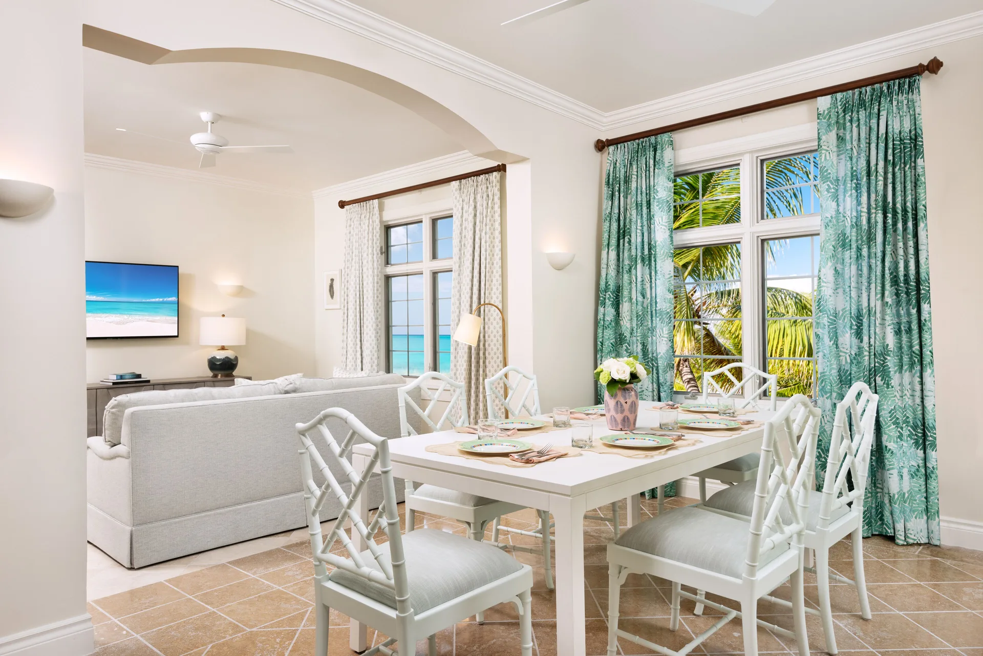 Suite dining area with table, living room, and ocean-facing windows at Point Grace.
