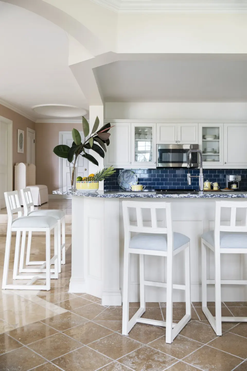 Suite kitchen island with white stools and blue backsplash at Point Grace.