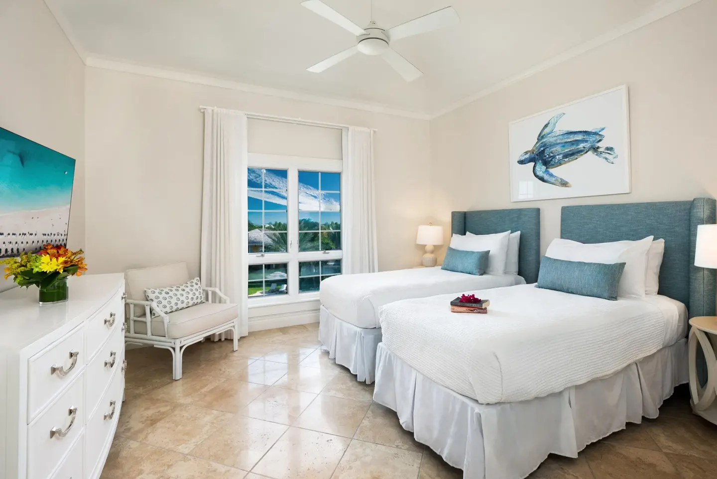 Two-bed guest room with turtle artwork and window view at Point Grace.