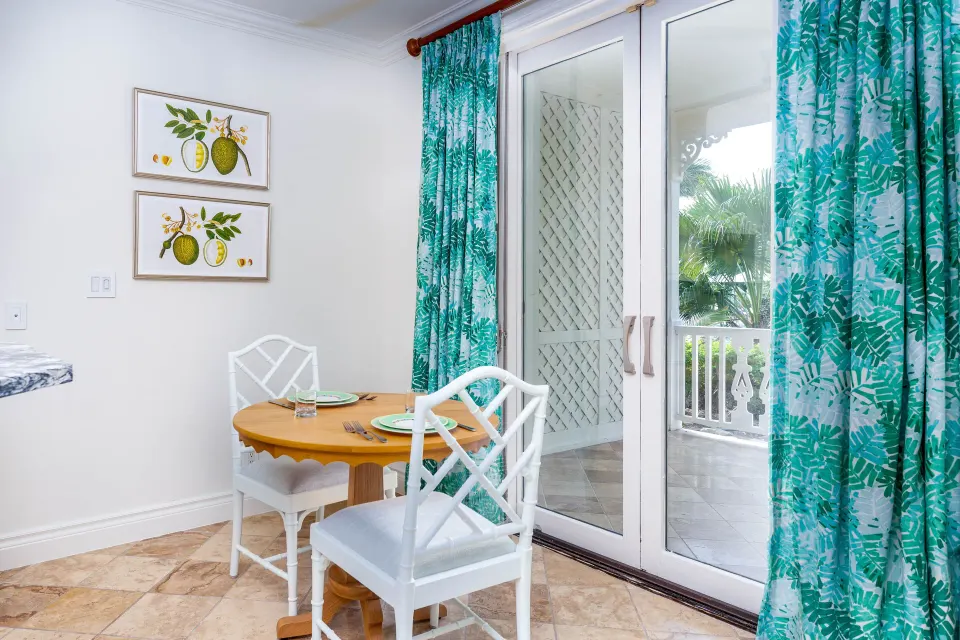 Dining nook and balcony doors in a Pool View Cottage 1 Bedroom Suite at Point Grace.