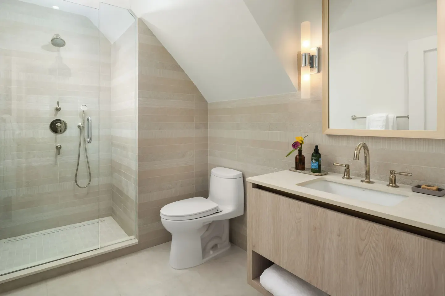 Oceanfront one-bedroom suite bathroom with shower, toilet, and vanity at Point Grace.