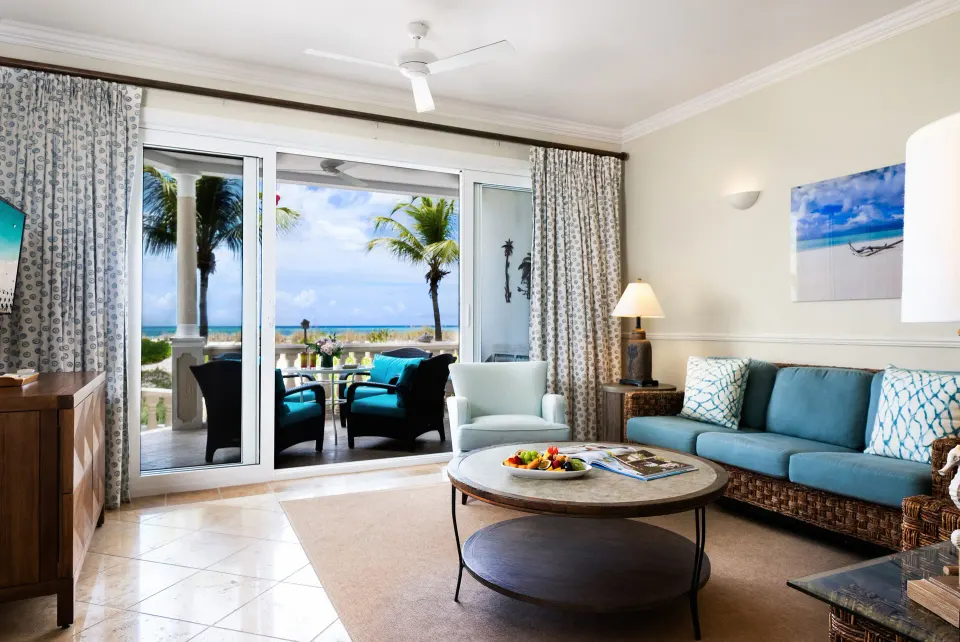Oceanfront one-bedroom suite living room with terrace and sea view at Point Grace.