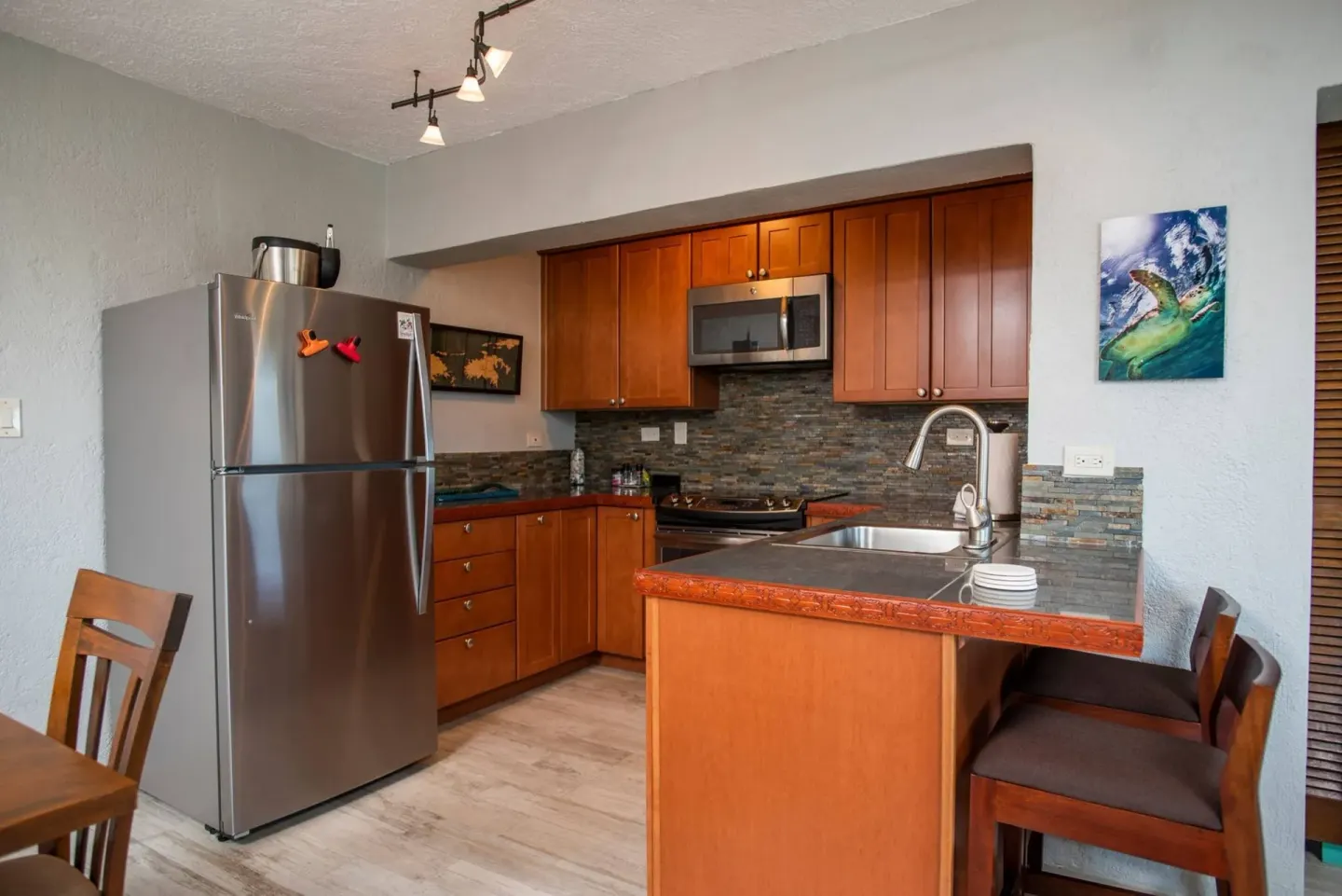Full kitchen with wood cabinets and stainless refrigerator at Point Pleasant Resort.