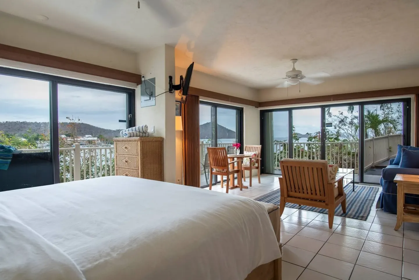 Guest room with king bed, sitting area and balcony views at Point Pleasant Resort.