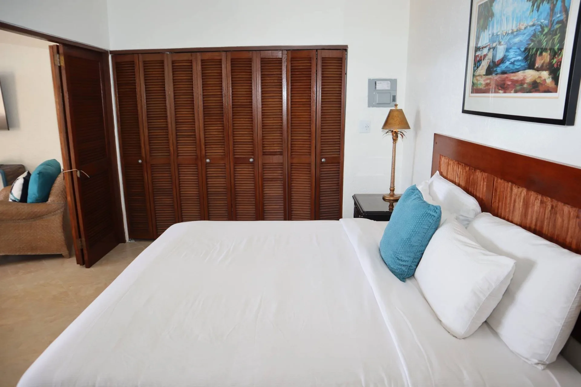 Guest room bed with wood closet doors at Point Pleasant Resort.
